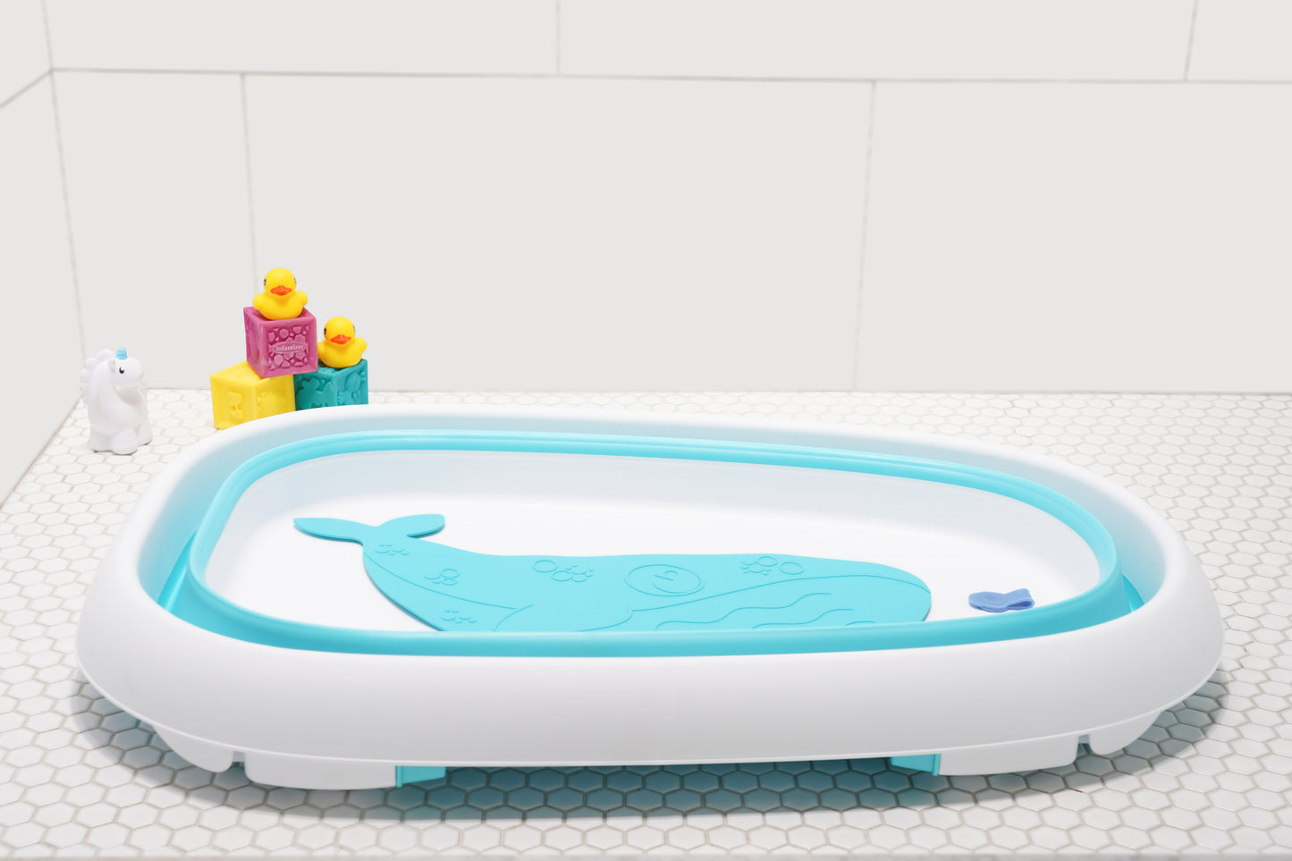 Baby sitting in the Original Tubee Tub safety bathtub – ergonomic and non-slip bath tub designed for newborn comfort and support during bath time