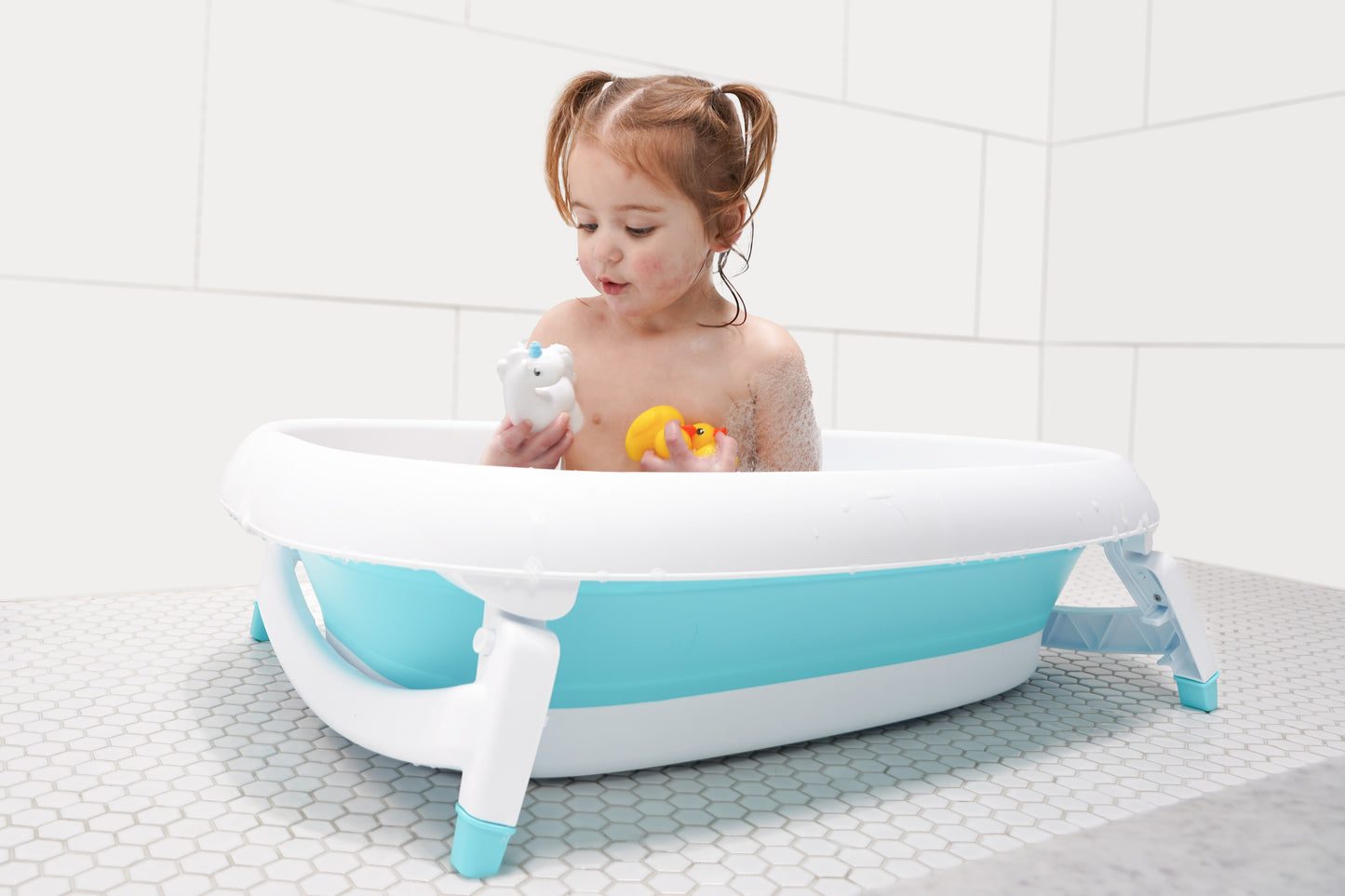 Baby sitting in the Original Tubee Tub safety bathtub – ergonomic and non-slip bath tub designed for newborn comfort and support during bath time