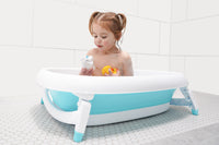 Baby sitting in the Original Tubee Tub safety bathtub – ergonomic and non-slip bath tub designed for newborn comfort and support during bath time