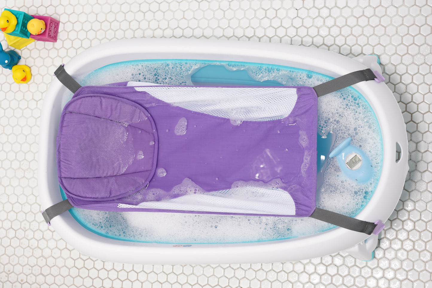 Purple baby bath hammock attached to a safety bathtub, designed for newborn comfort and support in the bath tub.
